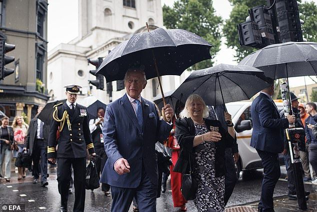 The monarch braved the rain on Thursday and came prepared with a sturdy umbrella
