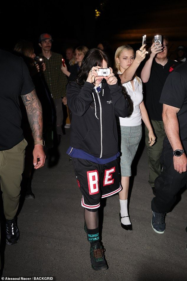 The hitmaker covered up in a black zip-up hoodie that was part of her own merchandise, and she also wore black 'B' and 'E' shorts with tall striped socks and black, green and red trainers