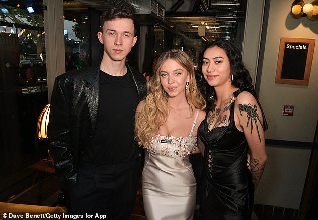 While her little brother Trent showed his pride for his sister as they posed for snaps together, cutting a trendy figure in a leather blazer, black trousers and aviator shades