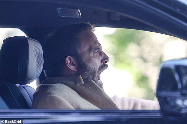 The bearded A-lister, who also let out a yawn, was dressed in stylish layers with a tie-free white shirt, a dark jacket and a thick tan cashmere overcoat