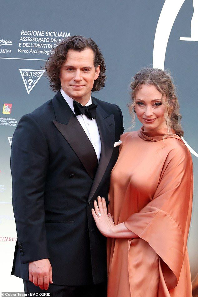 Henry Cavill cut quite the dapper figure as he showed off his flowing locks while posing with fiance Natalie Viscusso at the 71st Taormina Film Festival in Italy on Wednesday