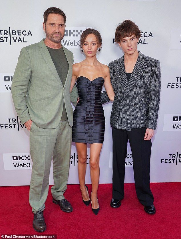 The actress teamed her stunning ensemble with chunky earrings and elevated her frame with stylish black heels (pictured with Gerard Butler, left, and Mason Thames, right)