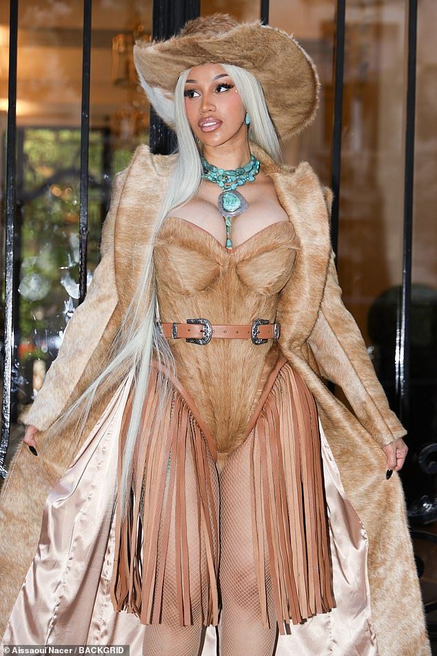 Finishing her cowboy themed ensemble, Cardi-B wore a matching fur hat, a blue teal statement and a long pale blue wig
