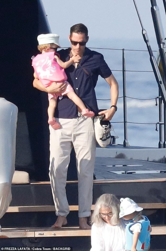 Carter kept his look simple in a navy blue linen short-sleeved button-down shirt with grey trousers