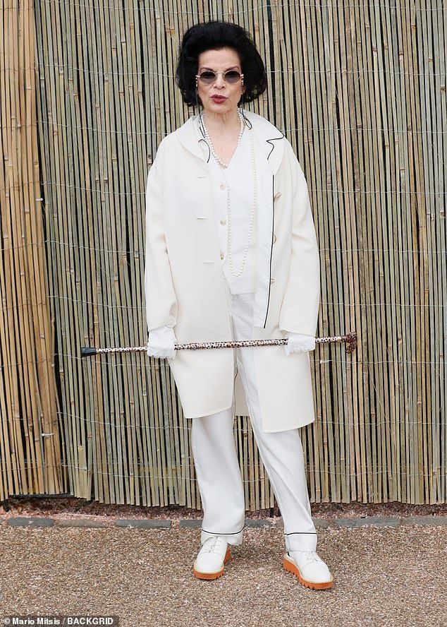 Bianca Jagger opted for an all cream ensemble, funky sunglasses and leopard print walking stick