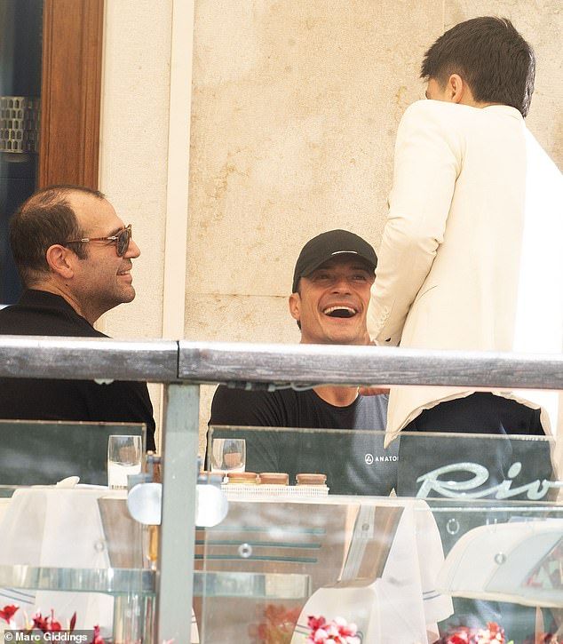 Orlando Bloom laughing on the balcony of his Venice hotel today ahead of the Bezos-Sanchez wedding