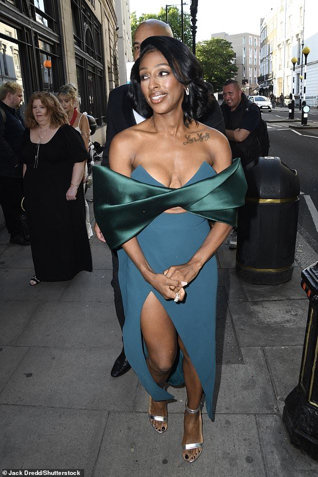 Alexandra Burke put on a busty display in a plunging blue side-split gown with an oversized green satin bow