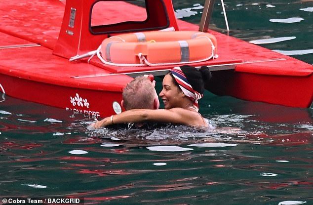 Lilian wrapped her arm around Boris's neck as they enjoyed a swim and gripped onto a small boat