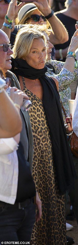 She hid her eyes behind dark sunglasses and wrapped a thick scarf around her, despite the UK heatwave