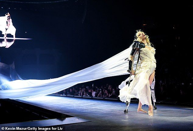 While her performance of enduring hit track, Paparazzi, saw Gaga don a white wedding gown with a long gauzy train flowing behind her as she strutted down the runway on silver crutches, like in the music video