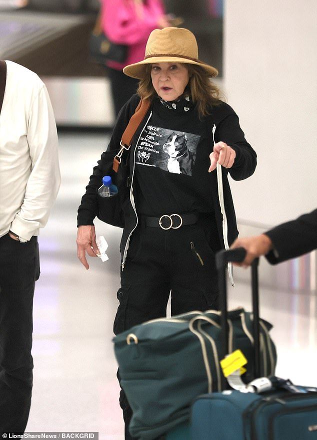 Blair cut a low-key figure in a black tee, straw hat and high waisted trousers as she wheeled her suitcase at LAX