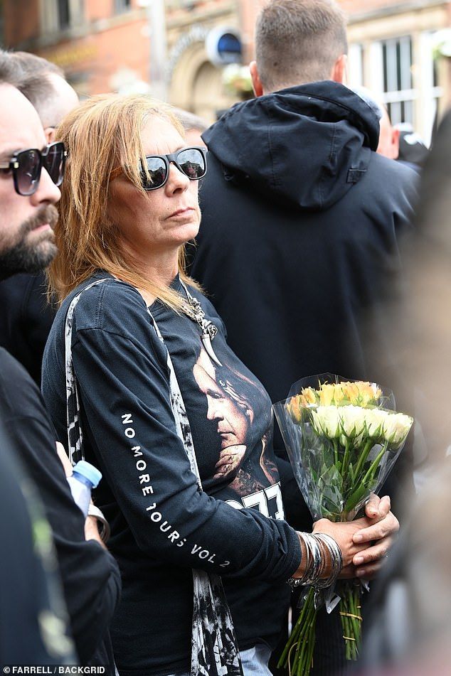 Fans awaiting the arrival of his funeral cortege held floral tributes