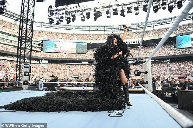 The rapper, 32, wore a huge, feathered cape, complete with a long train and fishnet stockings
