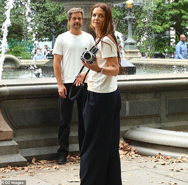 At one point Holmes held onto a camera as Jackson stood by a fountain in the park