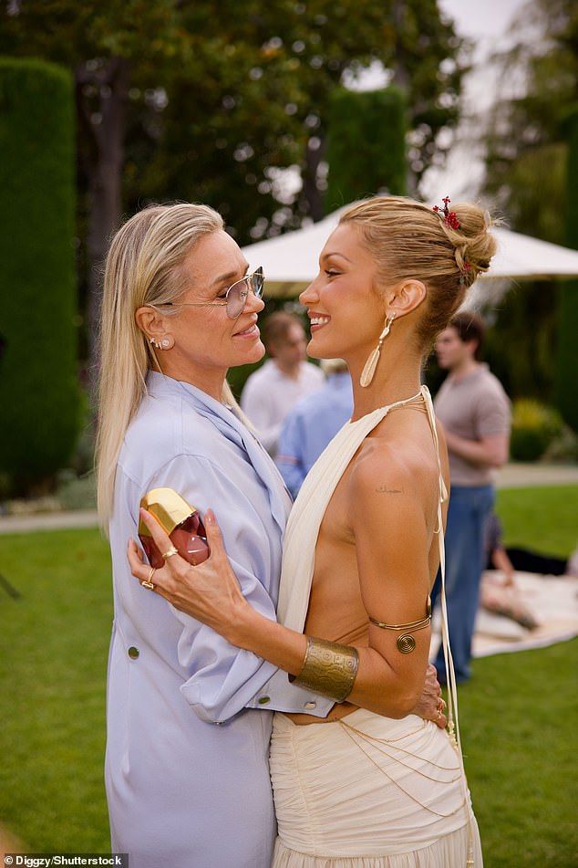 She paired the backless ensemble with white cowboy boots and accessorised with gold jewellery