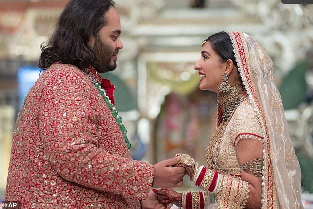 Anant Ambani holds the hands with his new brideRadhika Merchant at their wedding ceremony