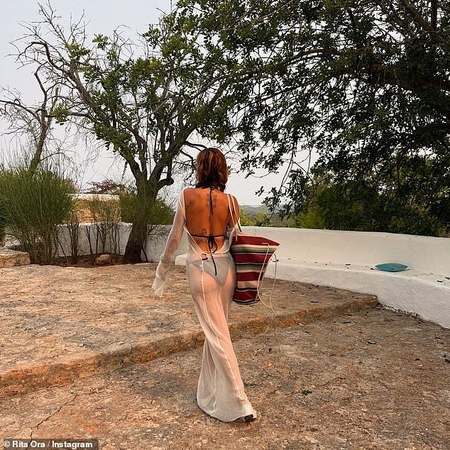 She later layered over a sheer maxi dress for an evening out and accessorised with an oversized straw bag
