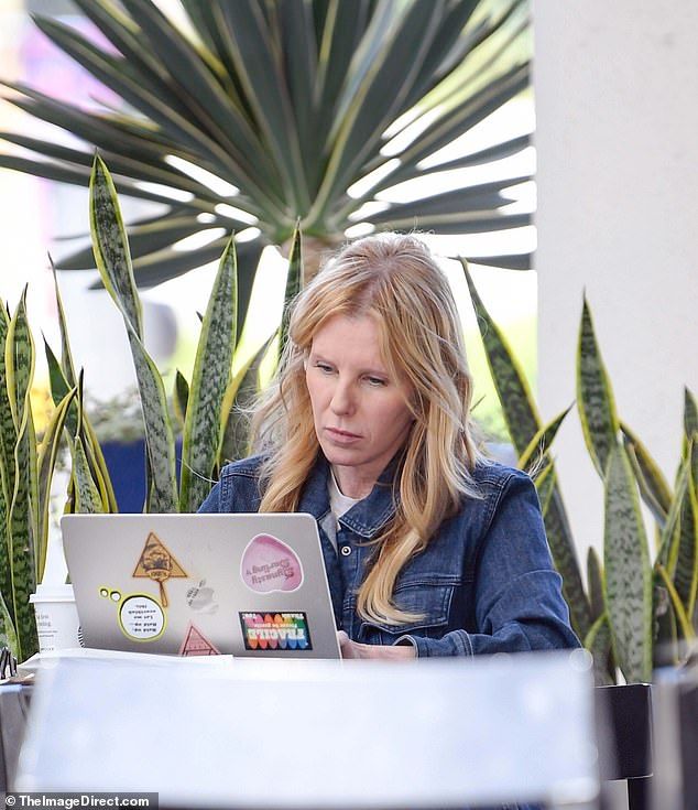 Her attention was fixed to her sticker-adorned laptop