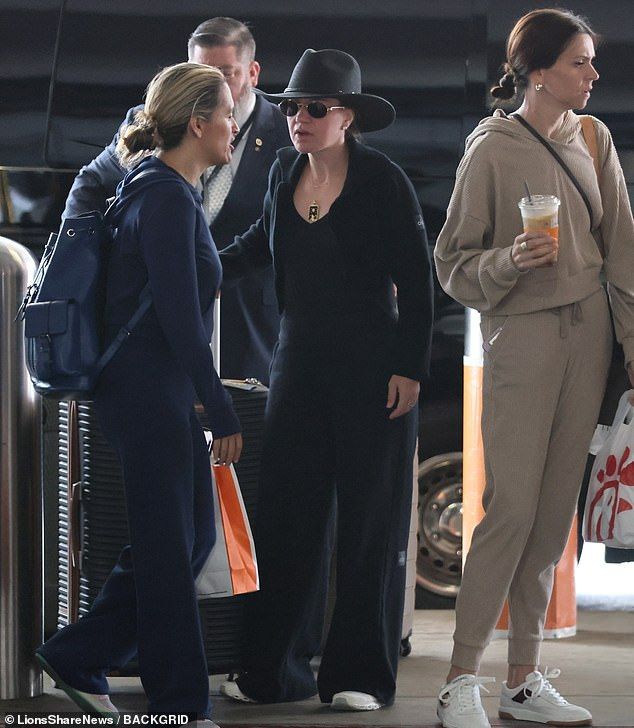 In photos exclusively obtained by the Daily Mail, the 43-year-old singer wore funereal black and guarded her eyes with shades as she arrived at LAX