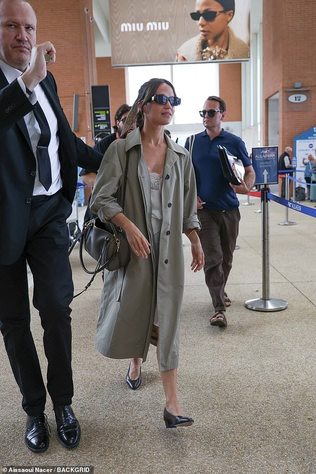 Beneath the coat, she wore a stylish white dress with delicate lace trims and opted for comfy black leather ballet flats
