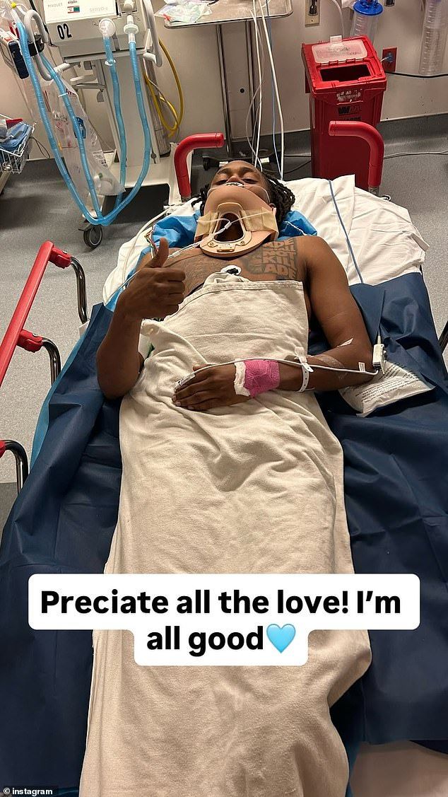 Taylor shared a jarring image of him in a hospital bed with a brace around his neck as he flashed a thumbs up gesture