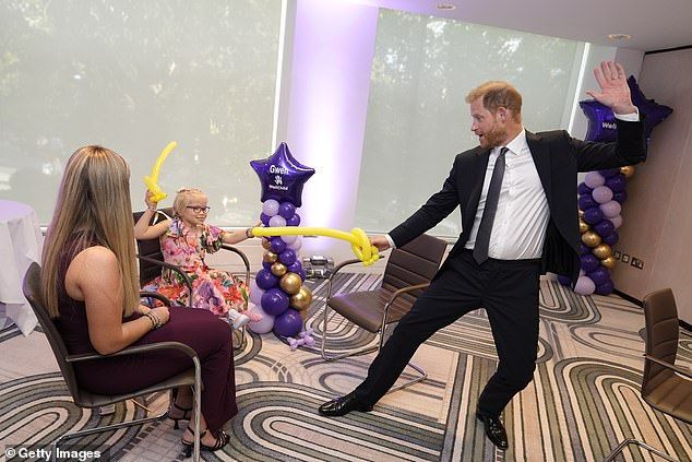 Prince Harry appeared to be back to his old 'fun self' at the WellChild Awards last night in London, delighting youngsters with a cheeky balloon sword fight (pictured) and sharing 'dad jokes' with teenagers
