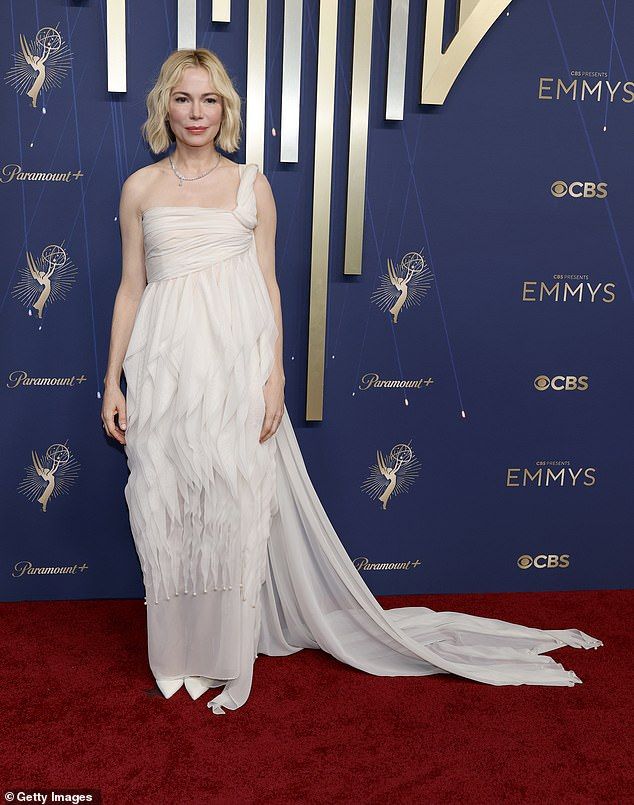 Michelle Williams, 45, appeared on the red carpet in a one-shouldered white dress with sheaths of fabric running in various directions that swamped her body and left an unflattering silhouette