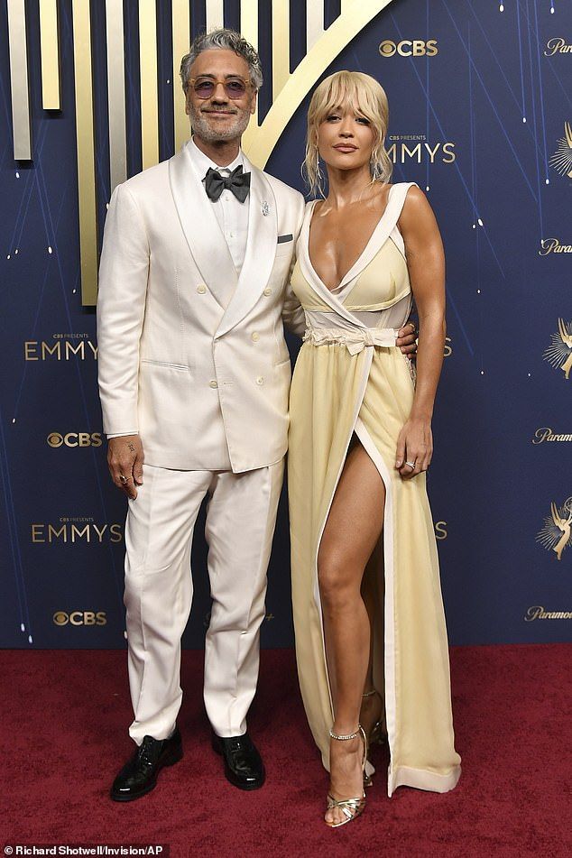 The British singer flaunted her jaw-dropping figure in a daringly plunging yellow and white gown which also boasted a racy thigh-high split