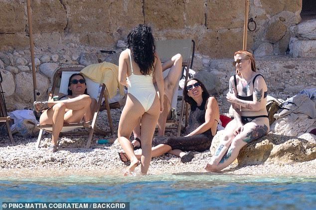 Charli chatter to her girl pals while paddling in the water