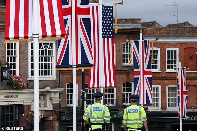 Police officers patrol as flags hang in Windsor town centre today during Donald Trump's visit