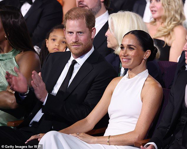 'Sitting in seats in the audience, we can see Meghan sitting to the front of the photo with her hand on Harrys thigh in a gesture of ownership,' the body language expert told Daily Mail