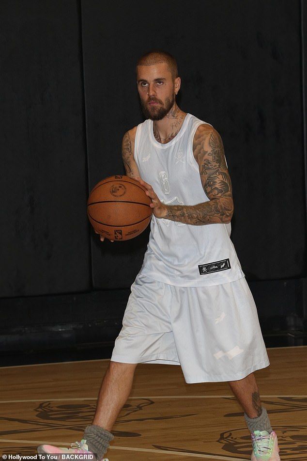 The pop star showed off his ball game skills as he took to the court, sporting a white tank and trunks