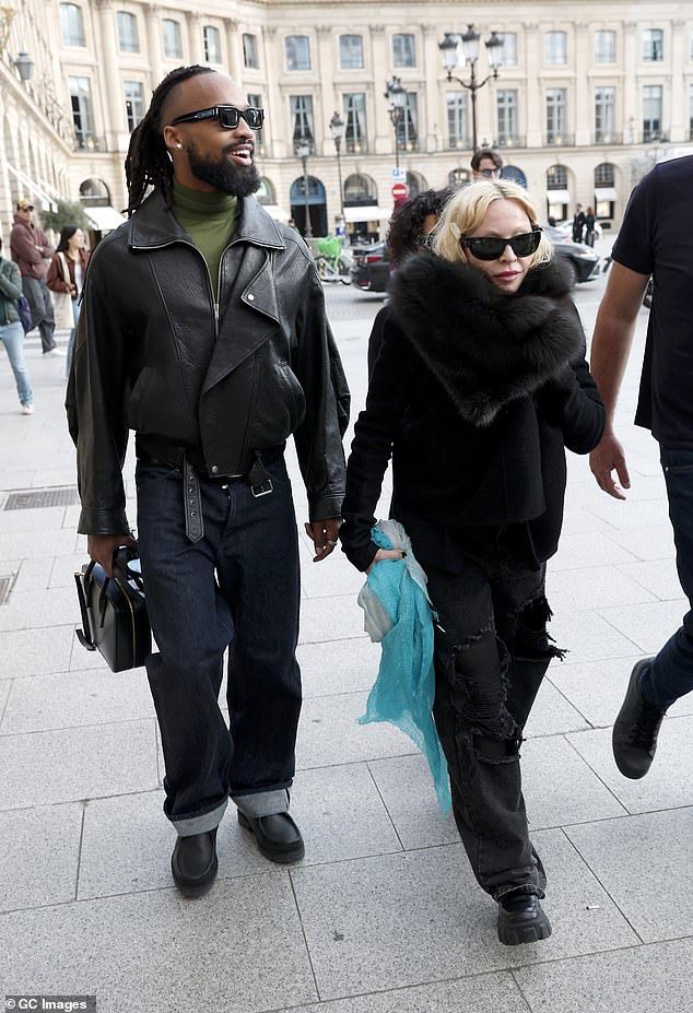 Madonna looked chic for the outing in a black suede wrap jacket featuring a huge fluffy collar, as well as ripped black jeans and chunky loafers