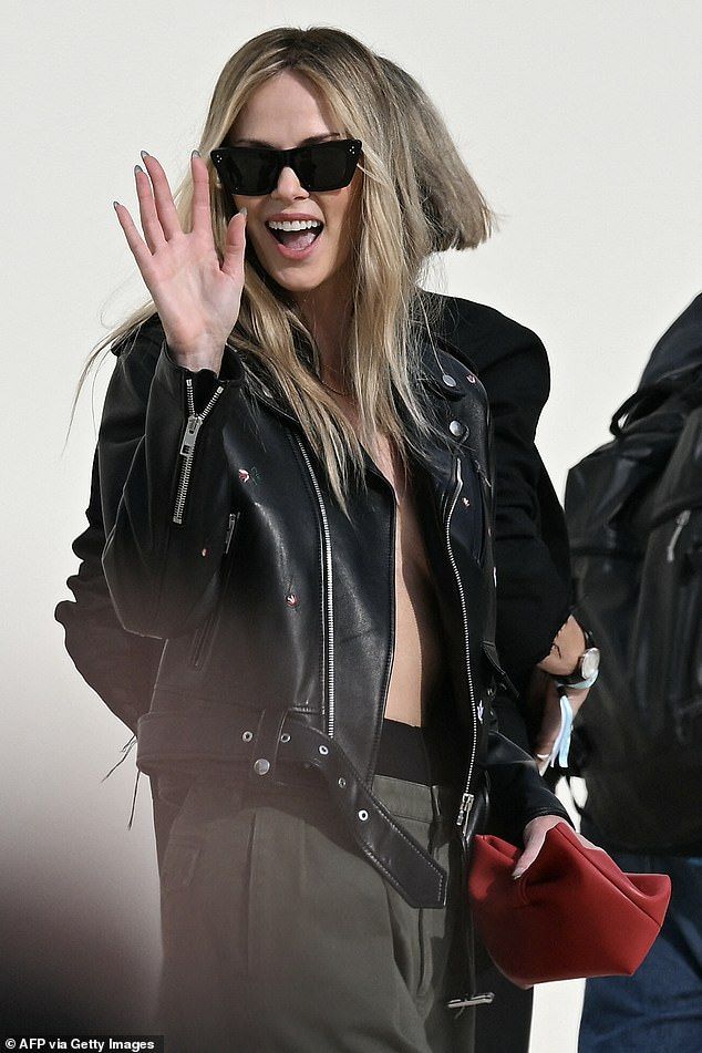 The actress flashed a hint of cleavage as she waved to fans and photographers after the runway show