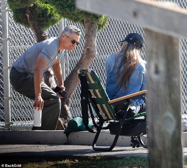 Meanwhile Warren, 46, kept it casual in a fitted gray t-shirt, cargo-style trousers, and Adidas sneakers