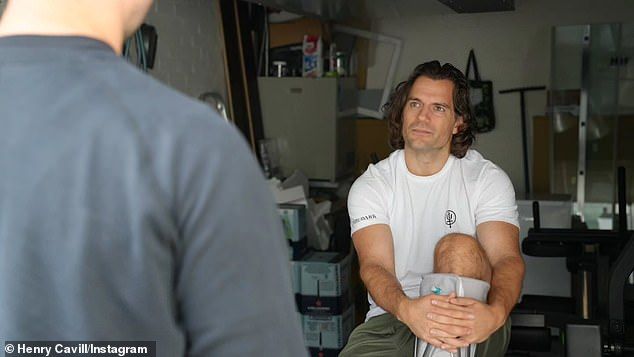 The British actor listens to his personal trainer while cradling his injured calf on Wednesday