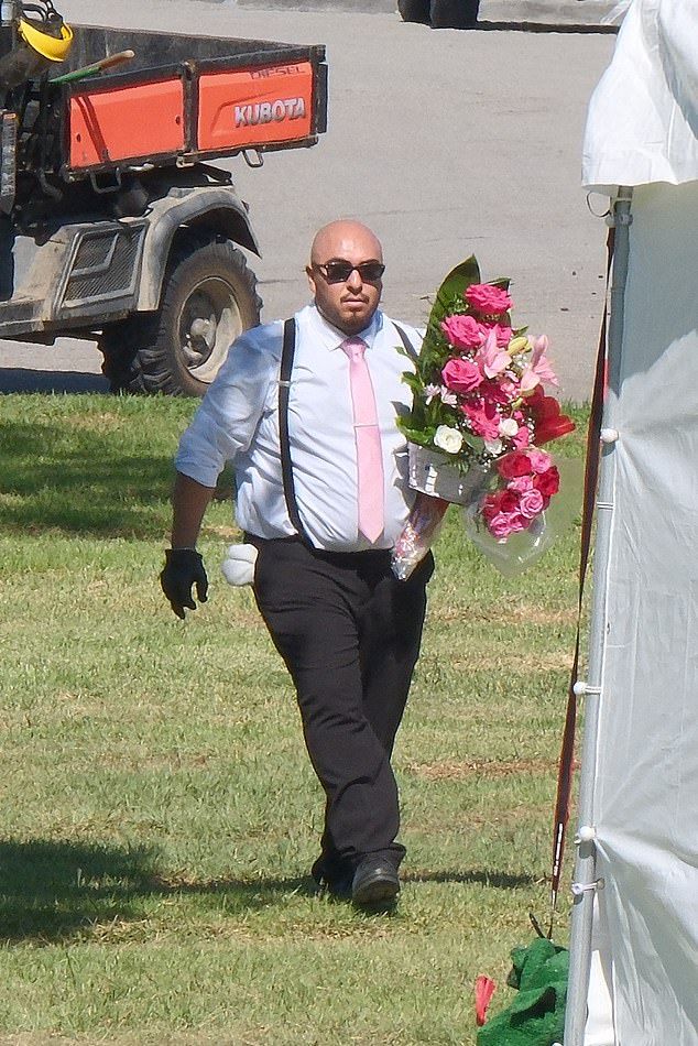 Several funeral attendees were seen carrying flowers to be left by the graveside