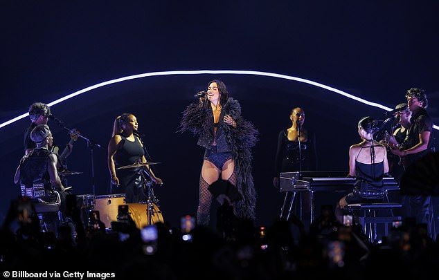 She highlighted her toned legs in the thigh-high stockings, which boasted a sequin fish-net design, and a pair of black heeled boots