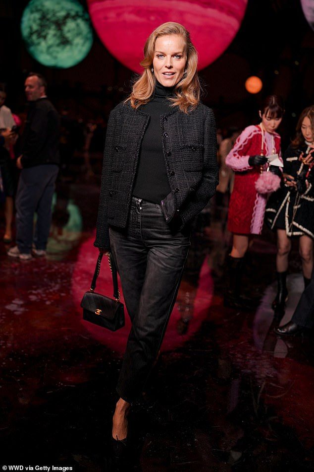 The Czech model looked youthful in a tailored black jacket over a turtleneck sweater and belted jeans as she held onto a purse. Her hair was a rich red color