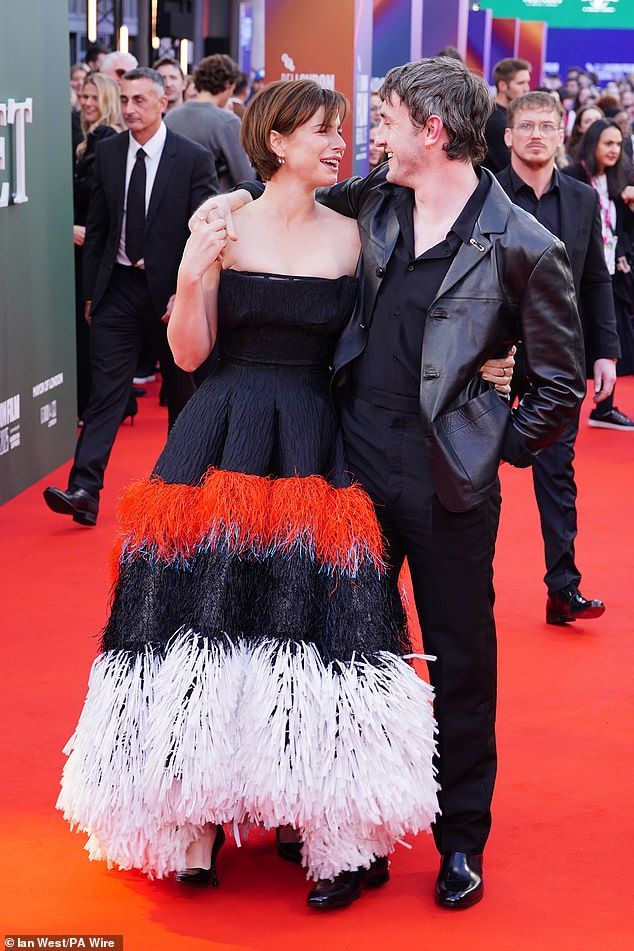 She elevated her look with pointed black heels and accessorised with elegant diamond drop earrings as she wrapped her arm around Paul as they caught up on the red carpet