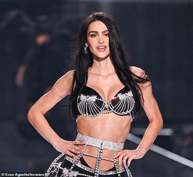 Her long raven hair was styled straight, flowing down her back and arms as she commanded the runway
